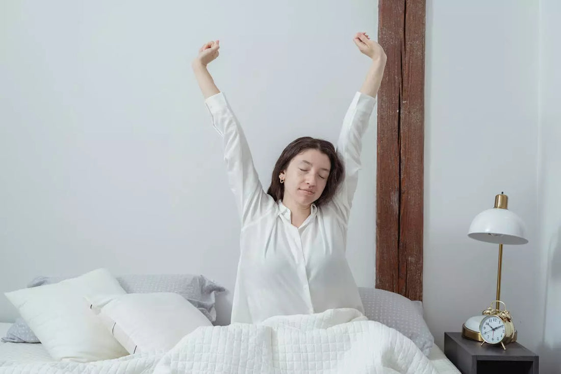 Image de l'article.  astuce pour un bon réveille matinal. Sur l'image on voit une femme sur son lit qui vient de ce réveiller et qui s'étire